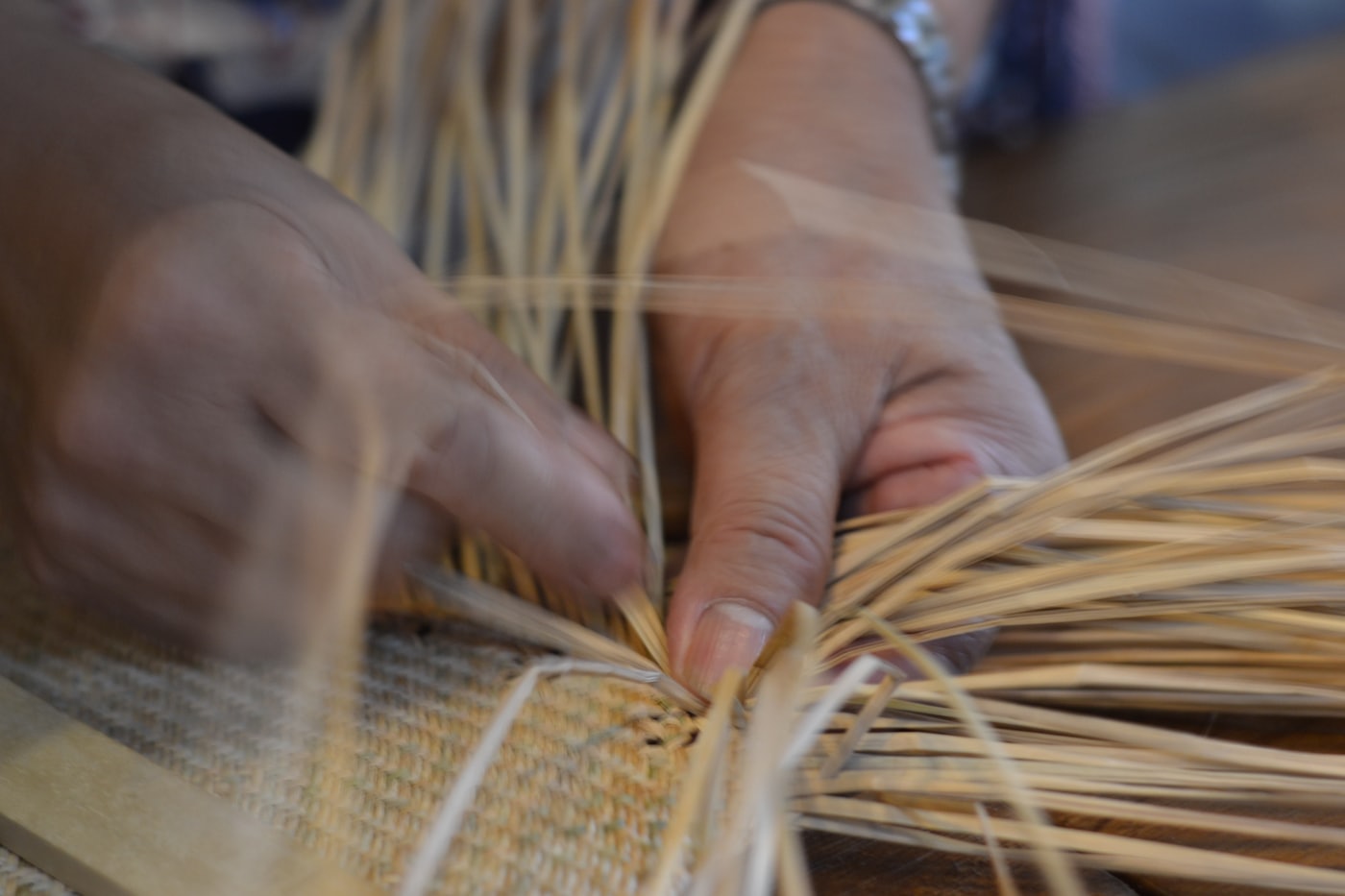 Hands weaving a keepsake box on the studio floor